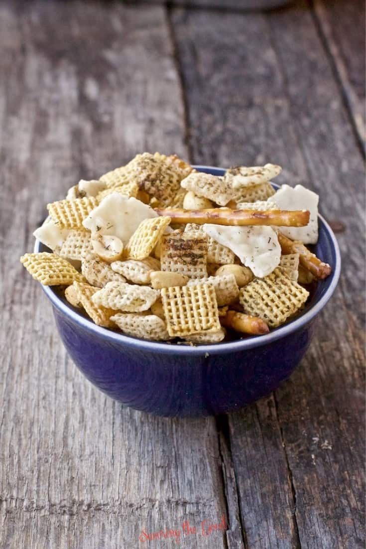 Dill Pickle Chex Mix Recipe in a blue bowl on a wooden surface