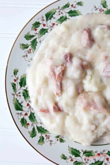 A plate of mashed potatoes with ham.