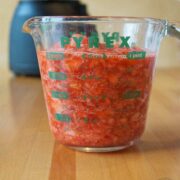A measuring cup filled with freezer strawberry jam.