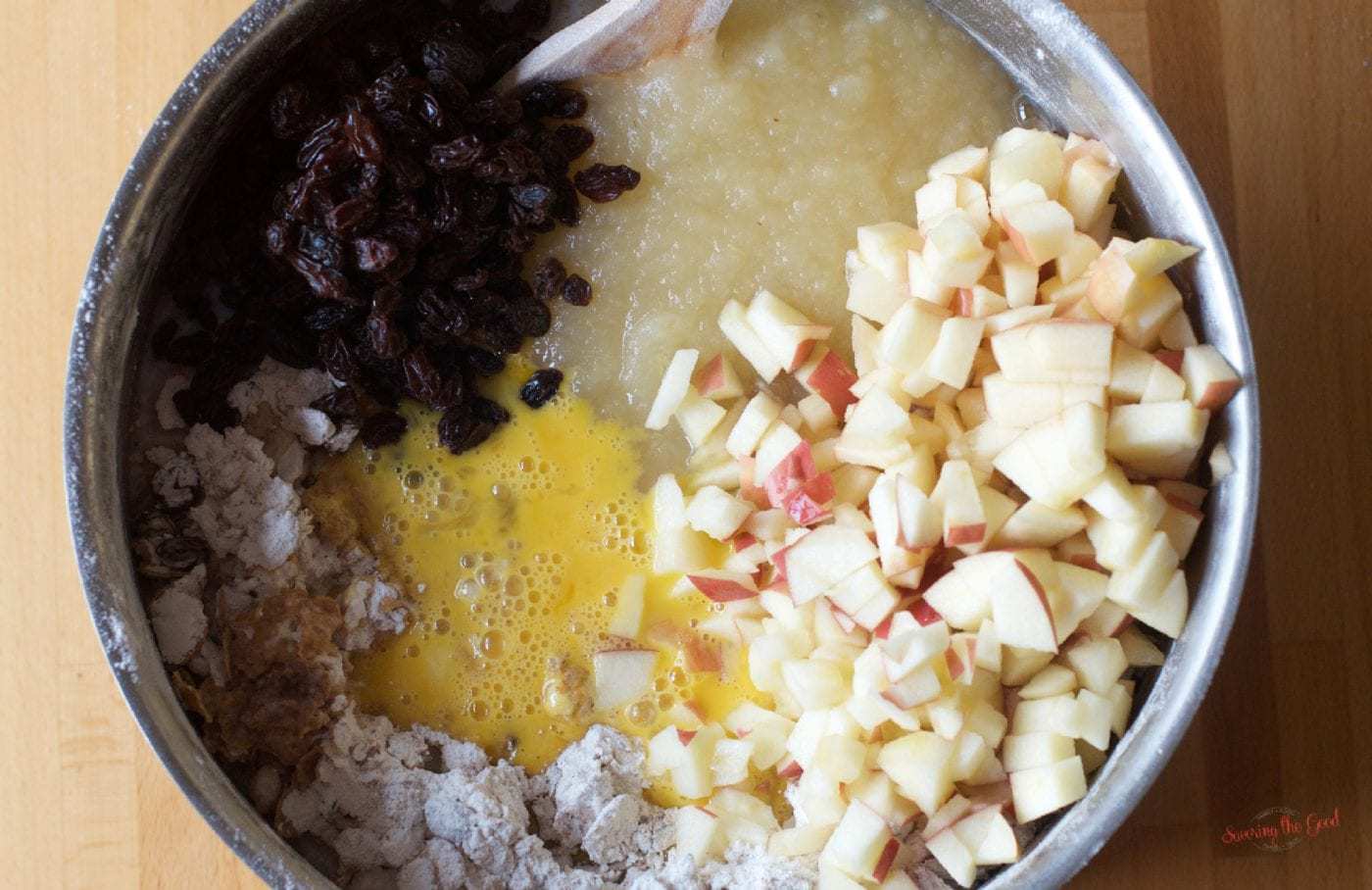 The ingredients for apple raisin bread in a bowl, including raisins and apples.