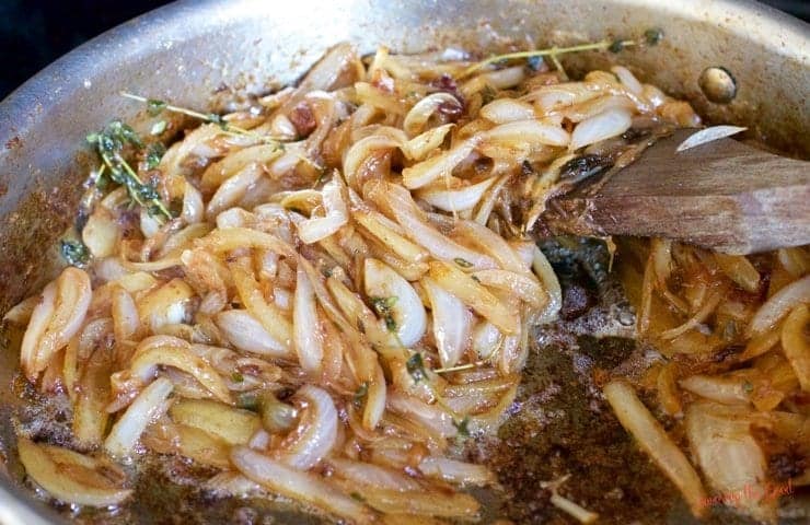 onions and thyme in a pan for bacon onion jam