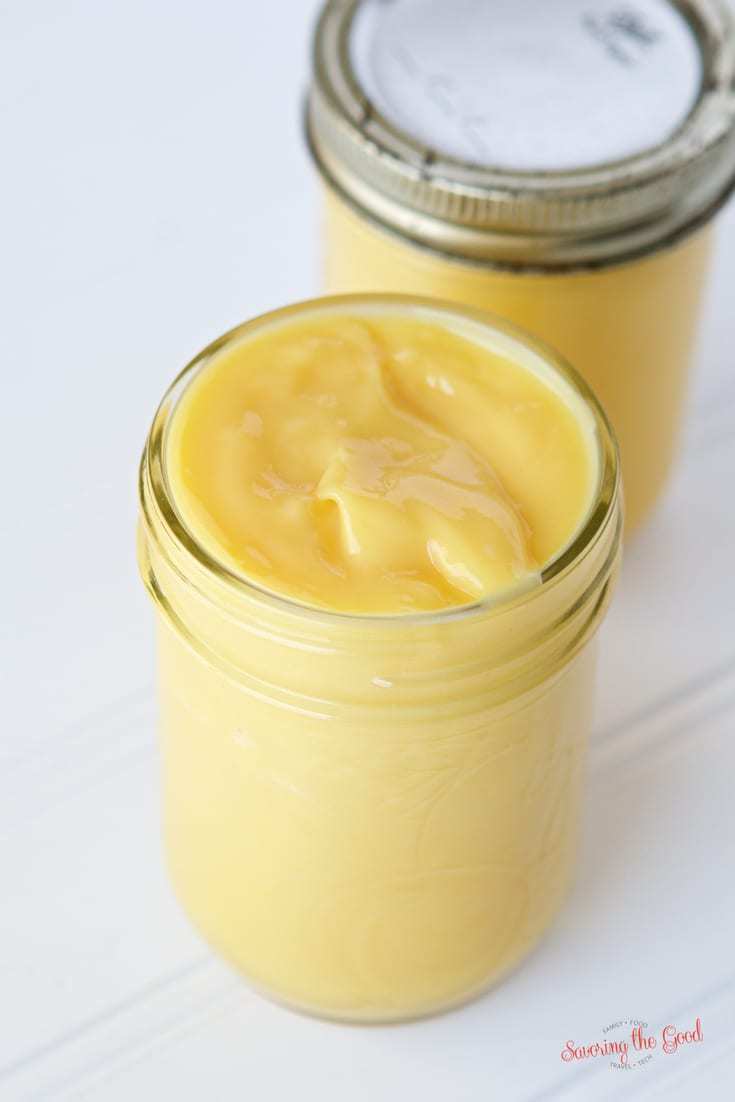 Two jars of lemon butter with Sous Vide Lemon Curd on a white table.