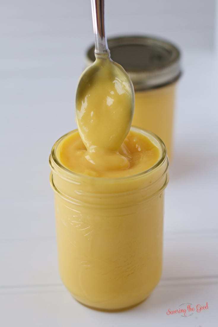 lemon curd in a jar with a spoon dipping in