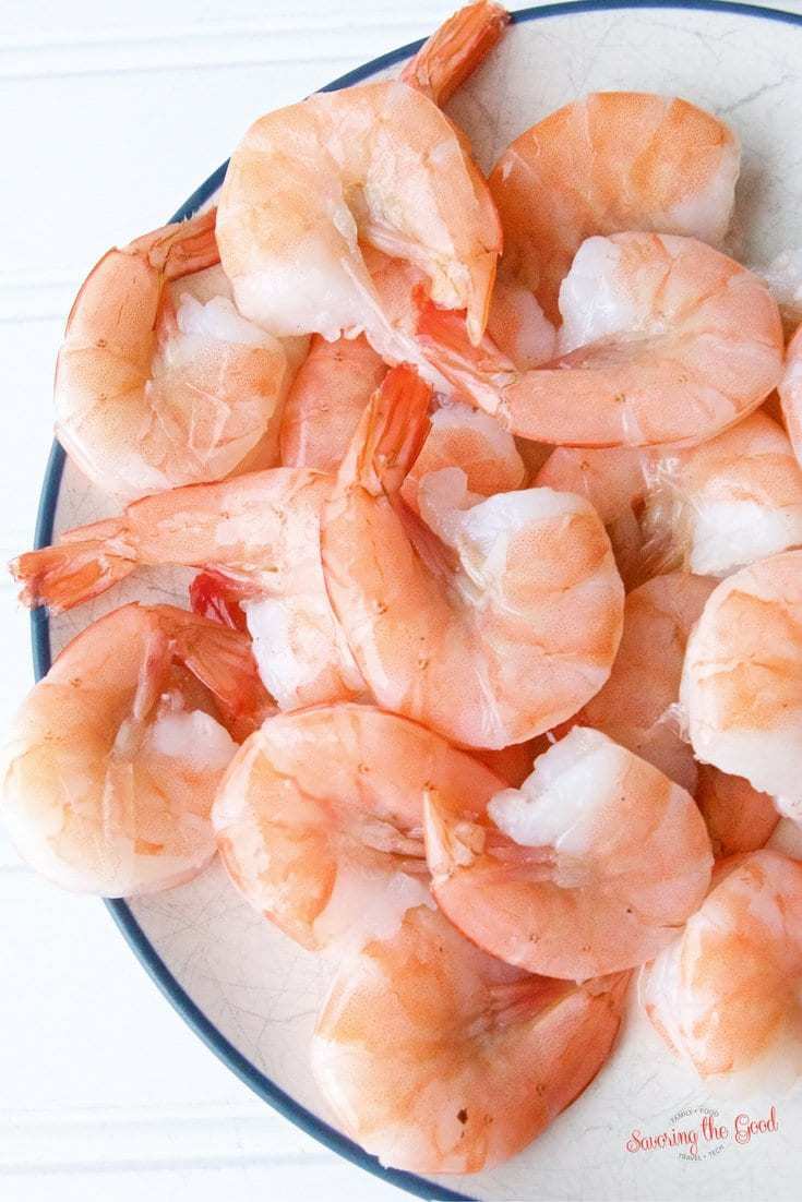 Explore a tantalizing sous vide shrimp recipe presented on a rustic wooden table, showcasing beautifully cooked shrimp delicately placed on a sleek white plate.