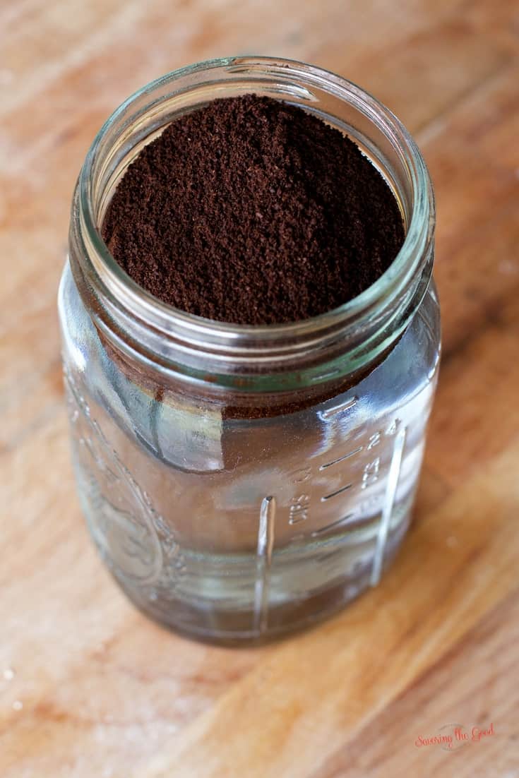 A jar filled with coffee powder on a wooden table.