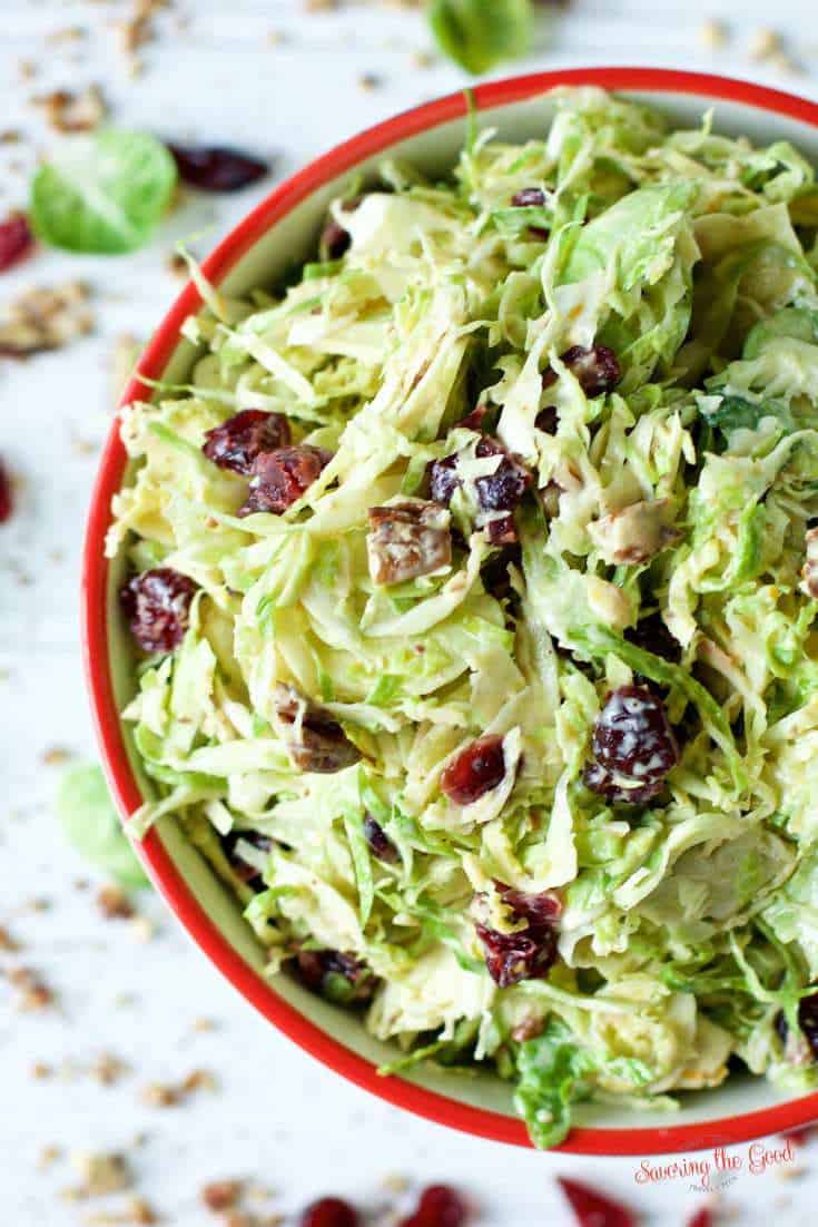 A bowl of Brussels sprout slaw with cranberries and nuts.