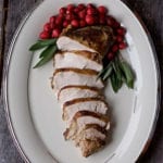 TheBest Sous Vide Turkey Breast on a Lenox serving platter on a wooden surface.