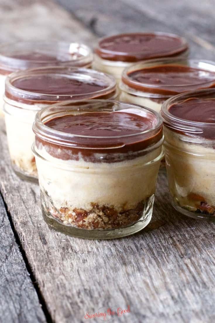 easy Sous Vide Peanut Butter Cheesecake in jars with chocolate ganache before the pretzel garnish