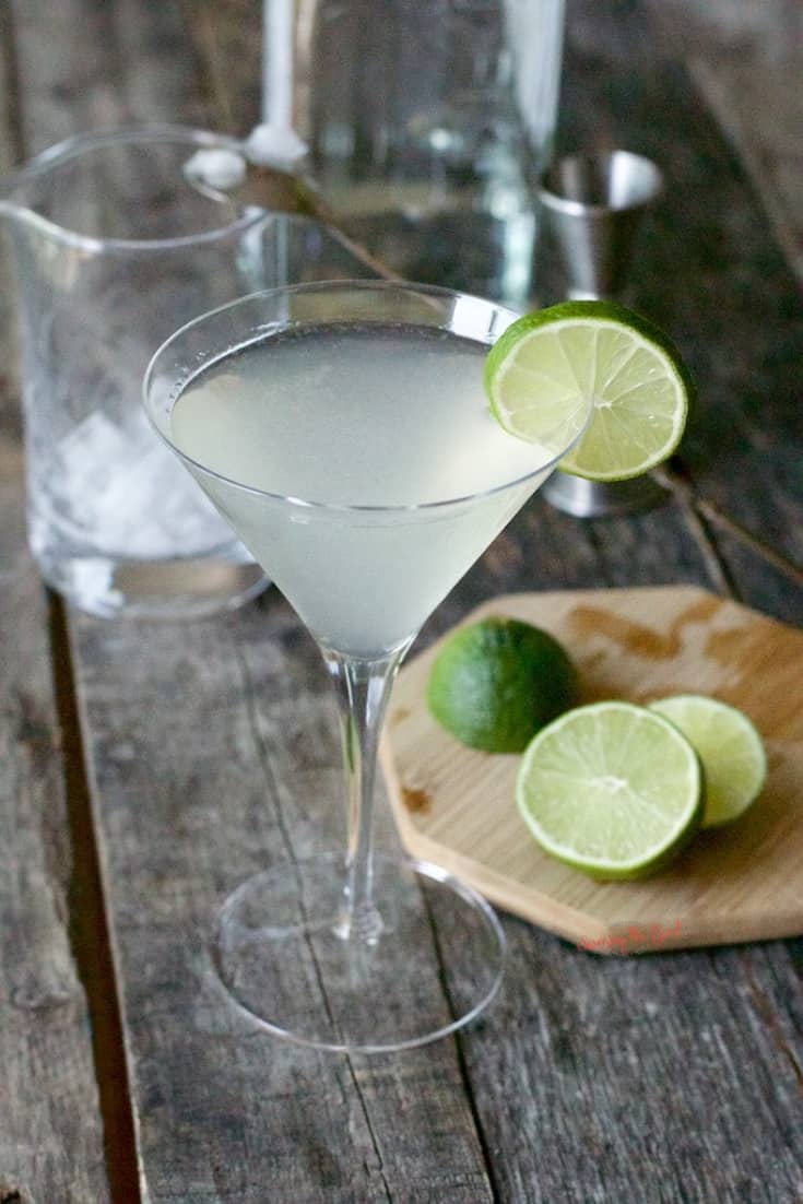 detailed shot of a Gimlet with bar accessories in the background