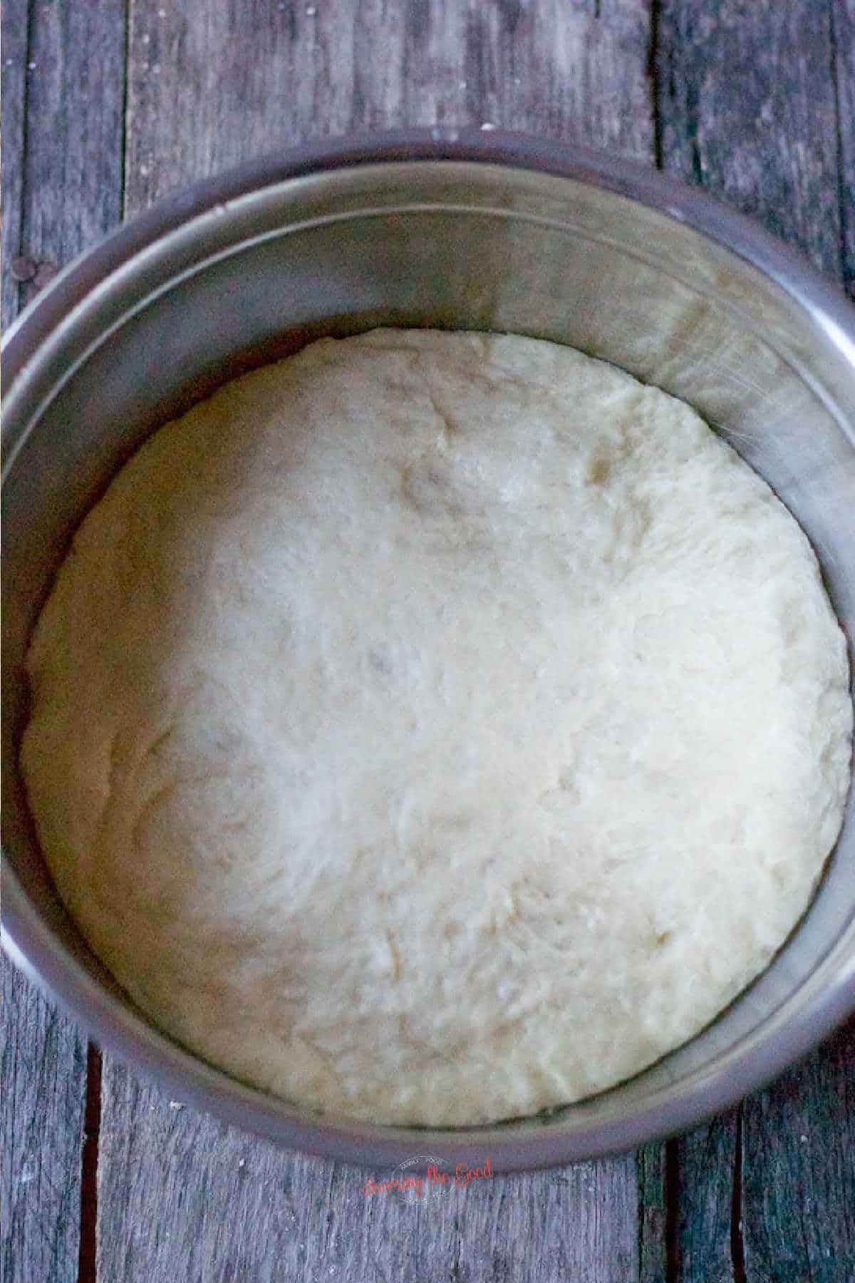 Naan Bread dough doubled in size in a stainless bowl