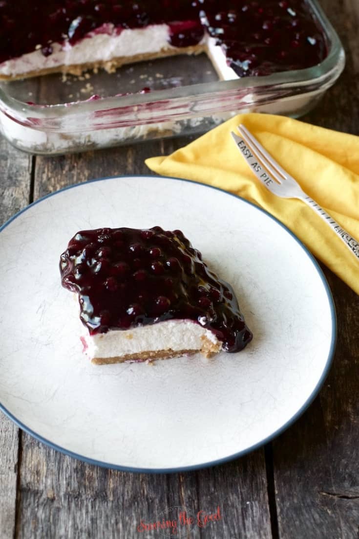 piece of Blueberry Delight on a white plate with yellow napkin to the side