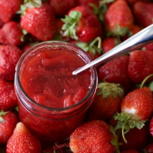 strawberry topping in a mason jar and silver spoon in it