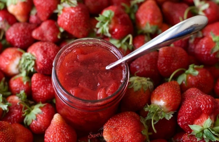 strawberry topping in a mason jar and silver spoon in it