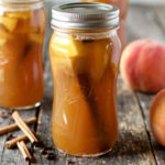 horizontal image of peach moonshine in a glass quart jar