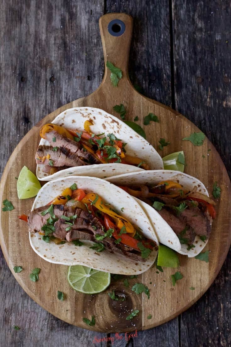 3 sous vide flank steak tacos on a round cutting board