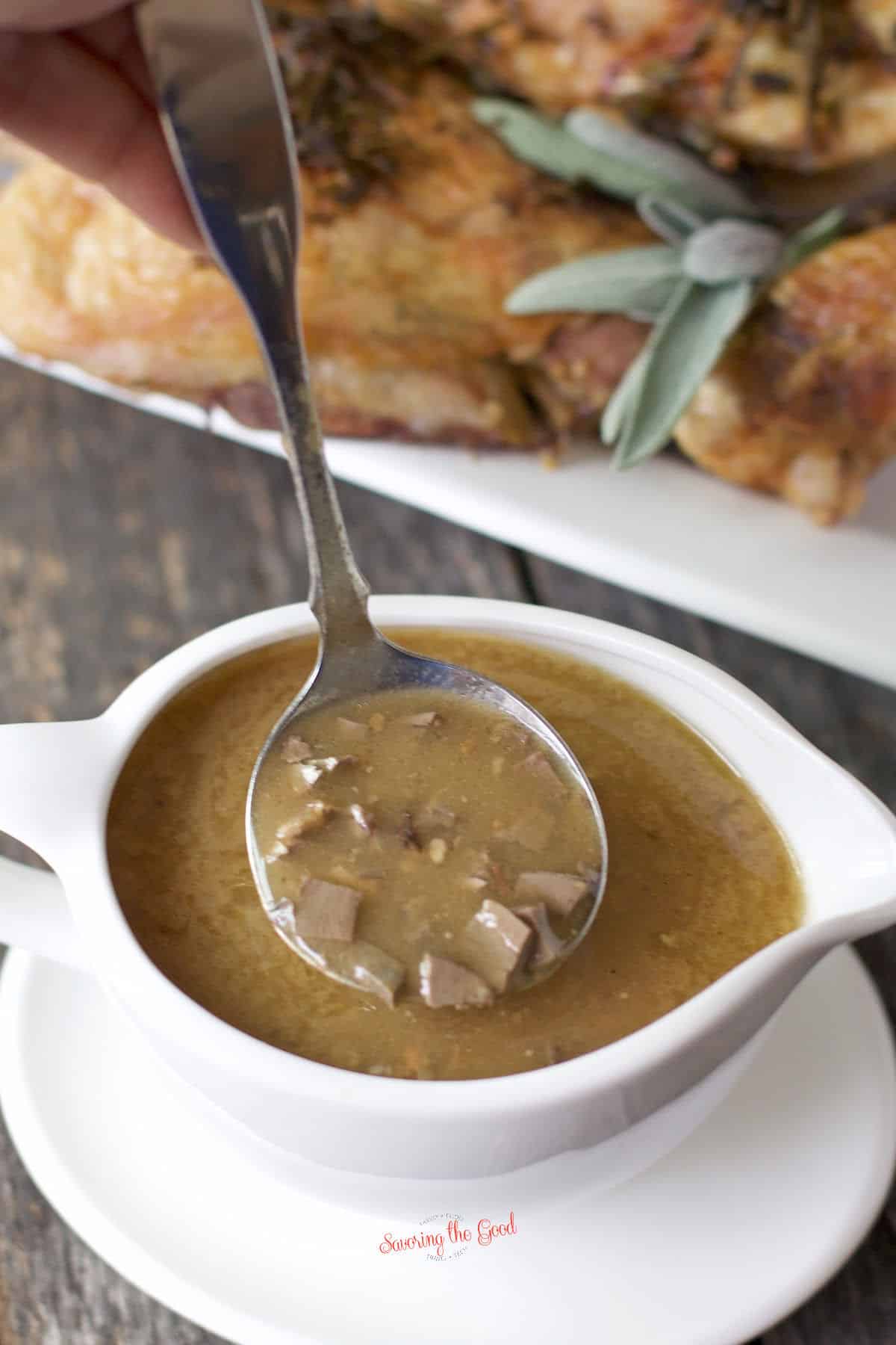 giblet gravy recipe with chunks of giblets being lifted from the gravy boat
