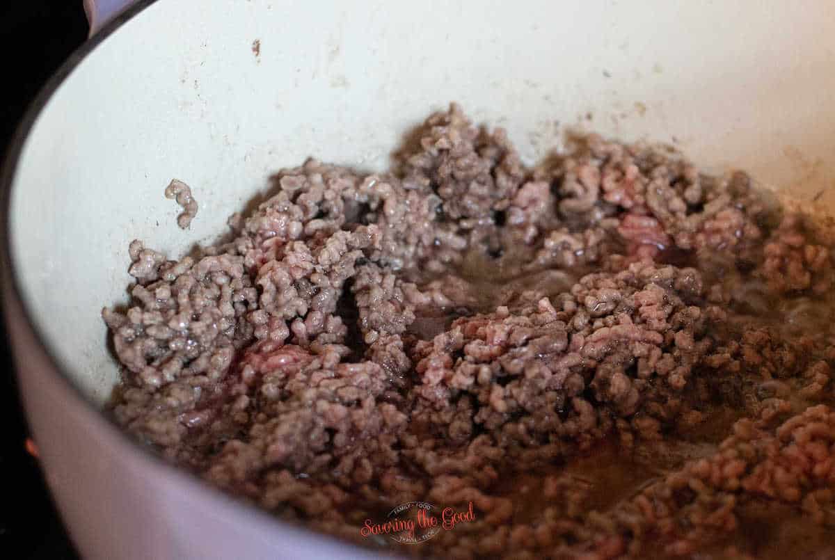 browned ground beef in a lilac enamel pot