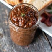 bacon jam on a serving knife with bread in the background