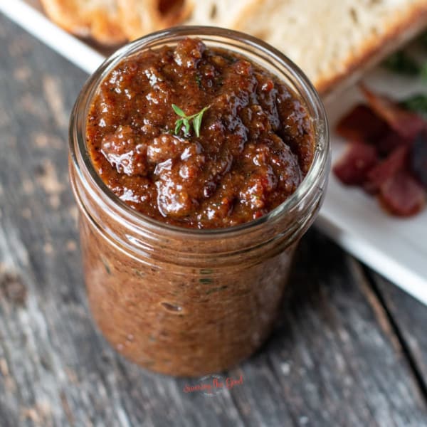 bacon jam on a serving knife with bread in the background