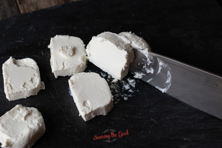 goat cheese being sliced into rounds for fried goat cheese