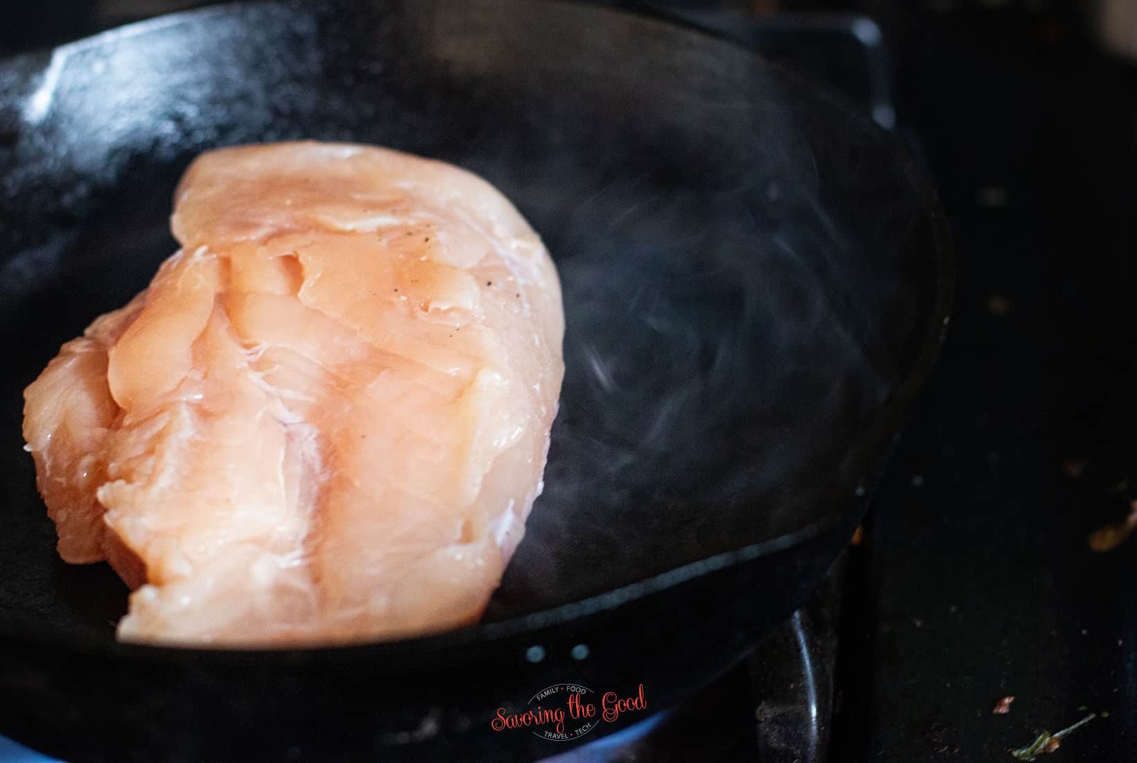 searing a chicken breast in a screaming hot cast iron pan