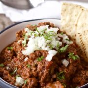 bowl of chili without beans garnished with chopped onions
