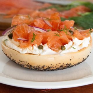 Salmon Lox Recipe featuring a toasted bagel, cream cheese, fresh dill, capers