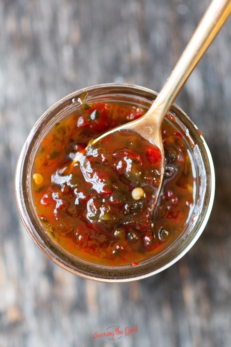 hot pepper jelly in a canning jar with a gold colored spoon