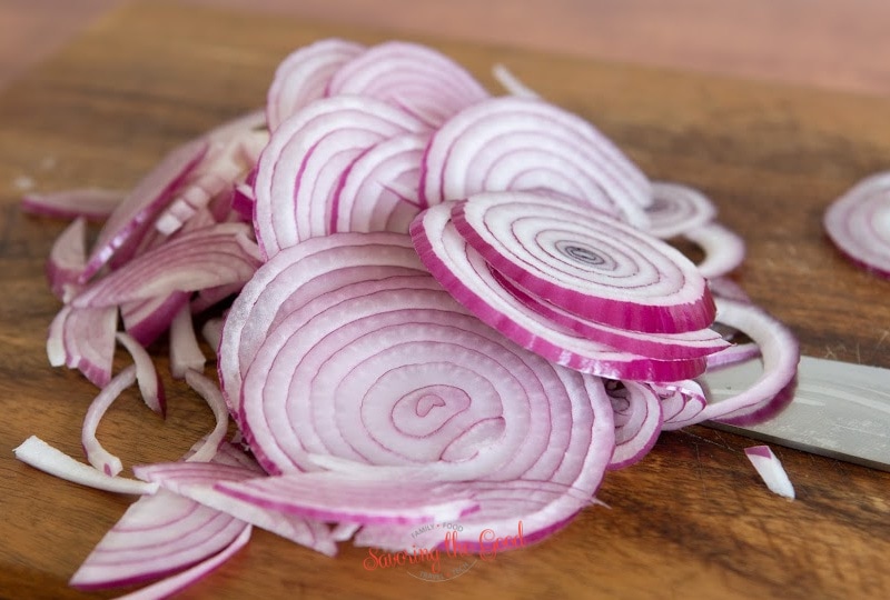 sliced red onions on a cutting board