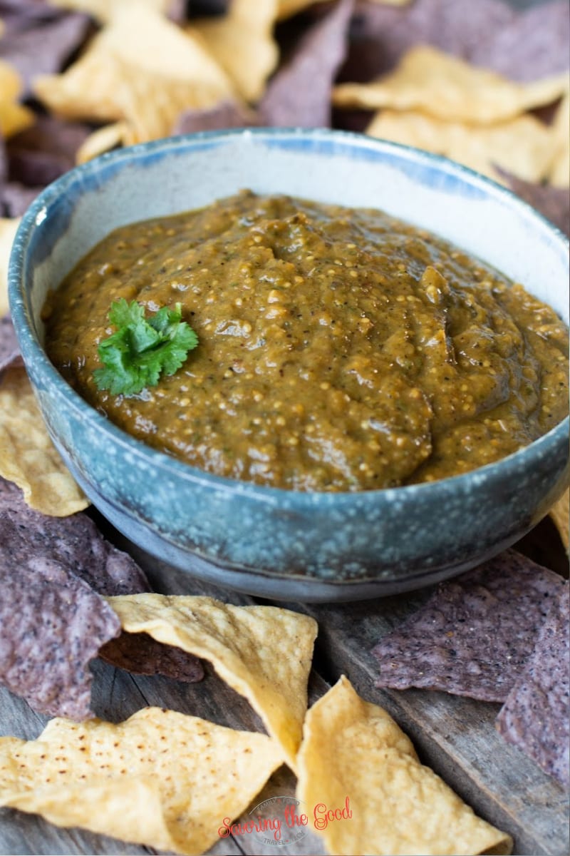 oven roasted tomatillo salsa in a blue bowl with chips on the side