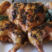 spatchcock turkey roasted golden brown, pressed flat on a serving platter, square image