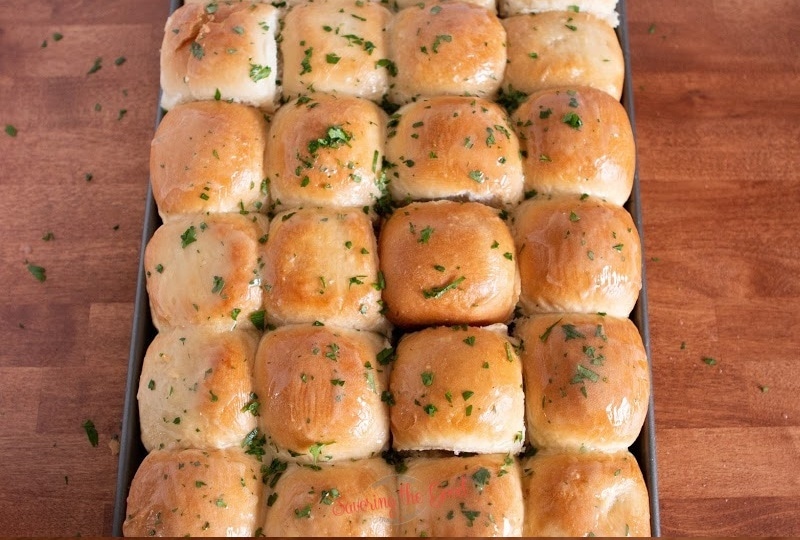 Rhodes Rolls with butter and fresh parsley in a sheet pan