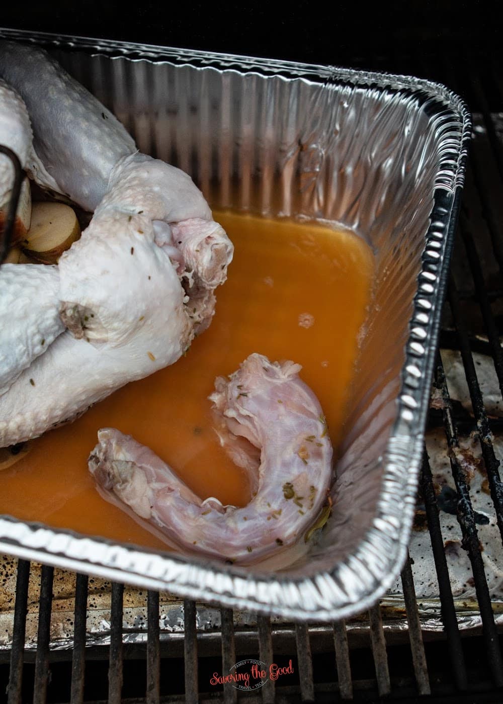 A turkey neck in a pan on the grill for a Whole smoked turkey