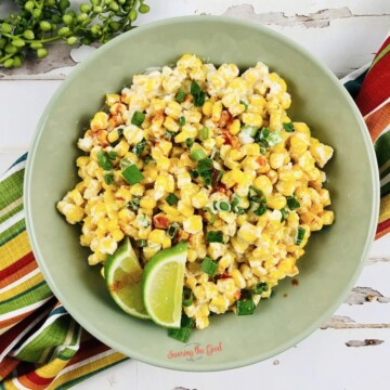 Mexican corn salad in a bowl with lime wedges, also known as Mexican corn casserole.