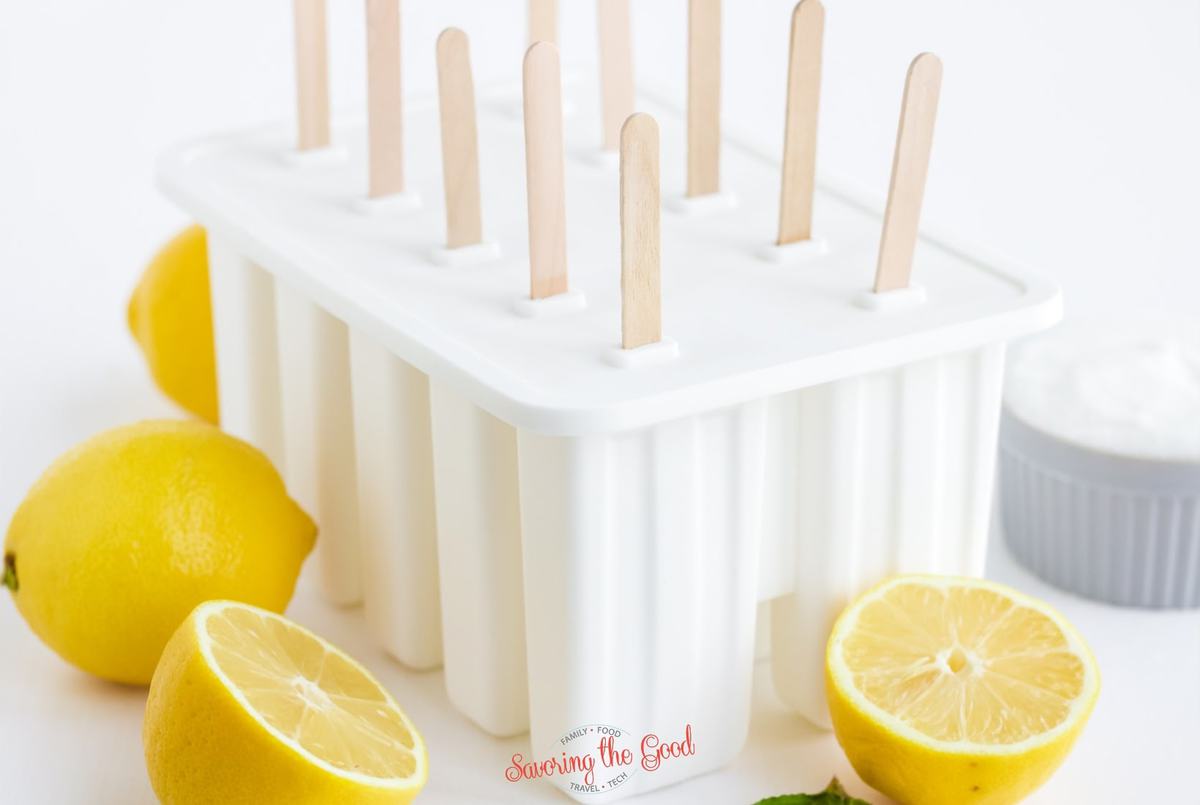 tray of Lemonade Popsicles in their molds, lemons as garnish
