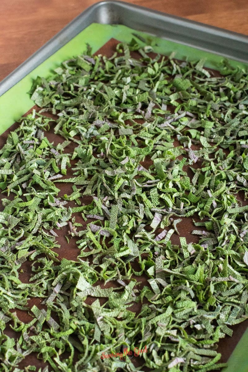 2 cups of fresh slices sage leaves on a sil pat non stick mat on a baking sheet