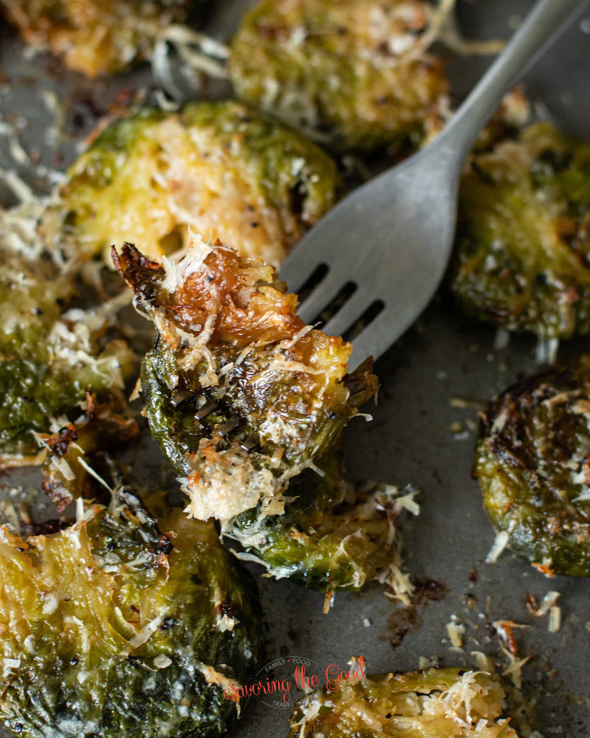 she pan of smashed Brussels sprouts with a fork picking up a single sprout showing texture