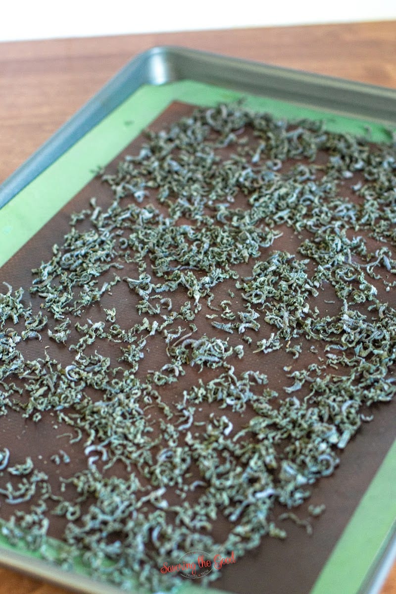 dried sage on a non stick mat on a sheet pan