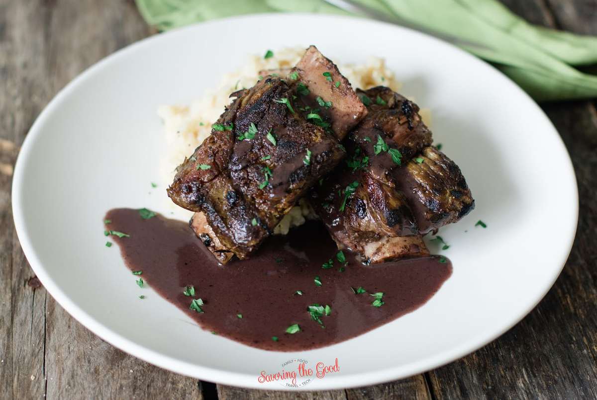seared Sous Vide Short Ribs on a white plate with red wine reduction