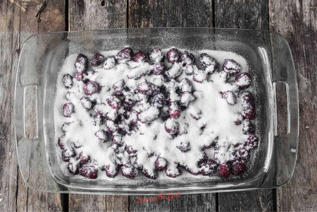 sugar sprinkled over blackberries in a 9 x 13 glass pan