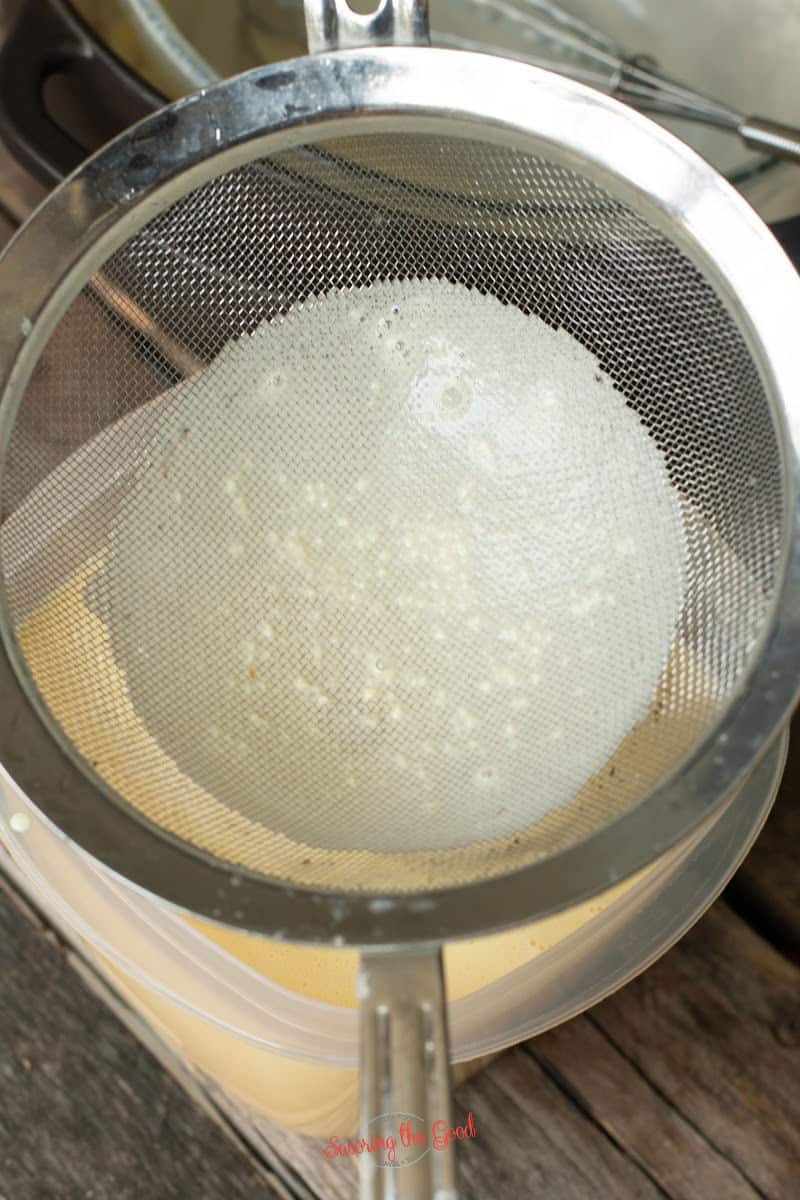 fine mesh strainer with bits of cooked egg in the strainer
