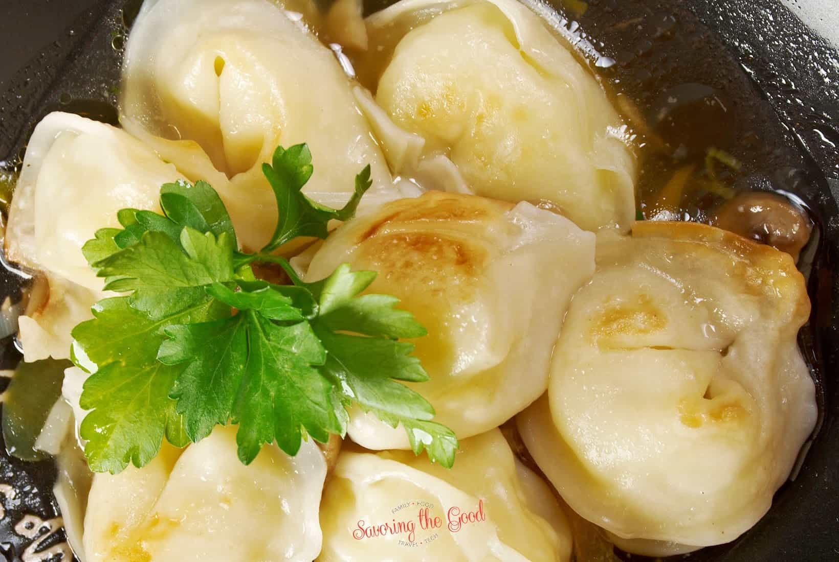 Dumplings in a black skillet with parsley.