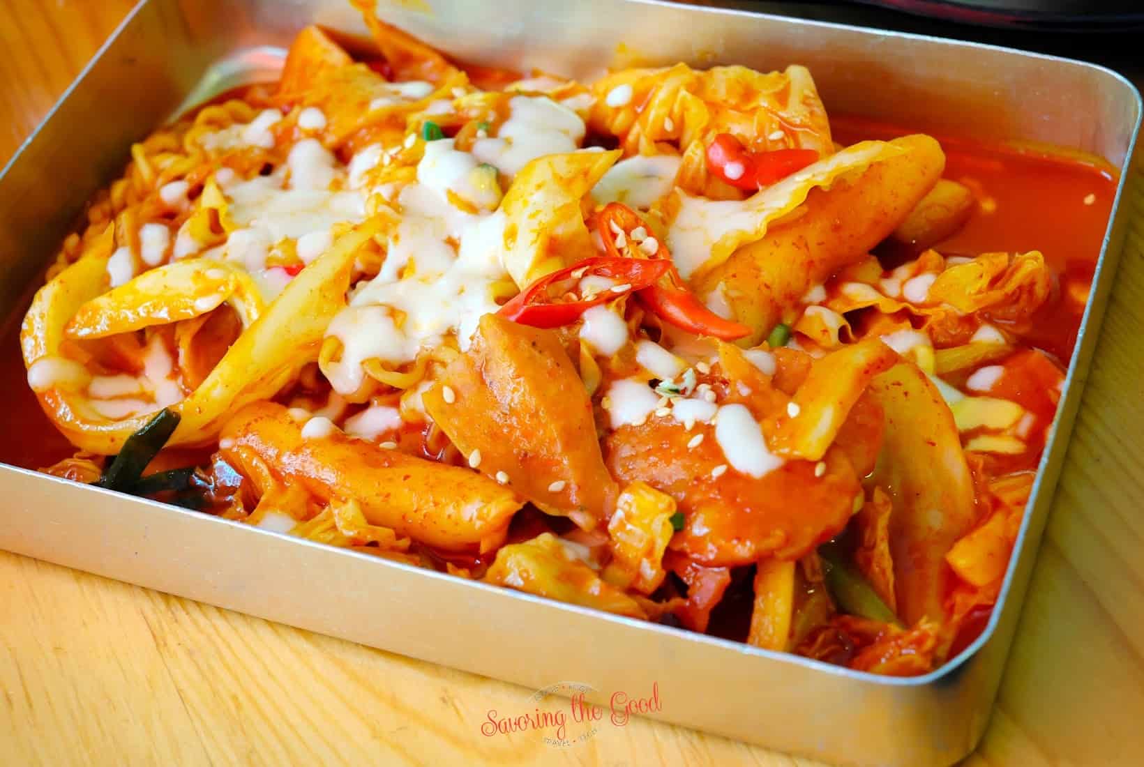 A metal container with food in it.tteokbokki.