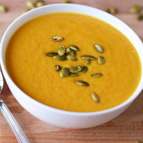 Autumn Squash Soup in a white bowl with pepita garnish in a white bowl