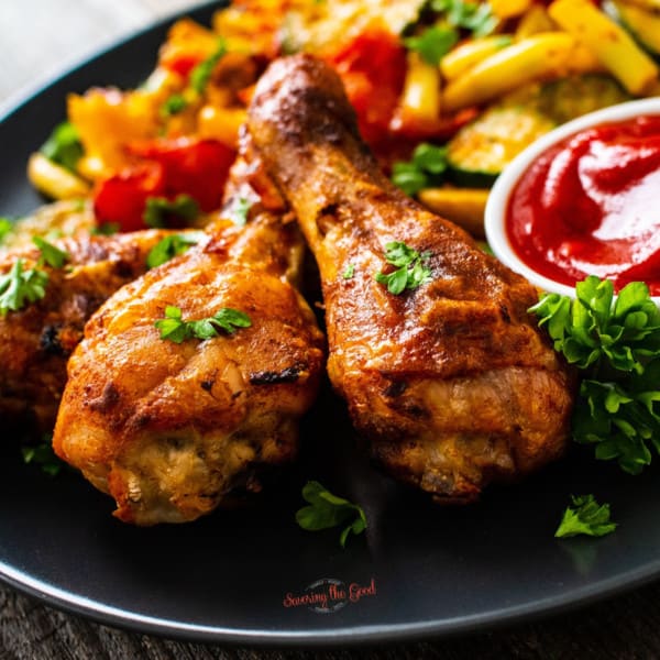 chicken drumsticks with fries and ketchup on a plate.for a featured image on what to serve with chicken drumsticks.