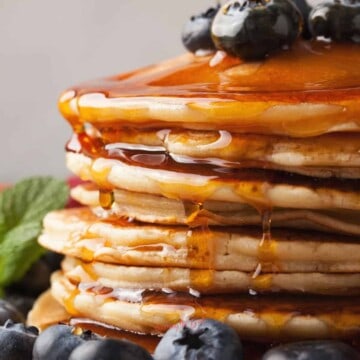 A stack of pancakes with syrup and blueberries.as feature image for Recipes that Use Pancake Mix