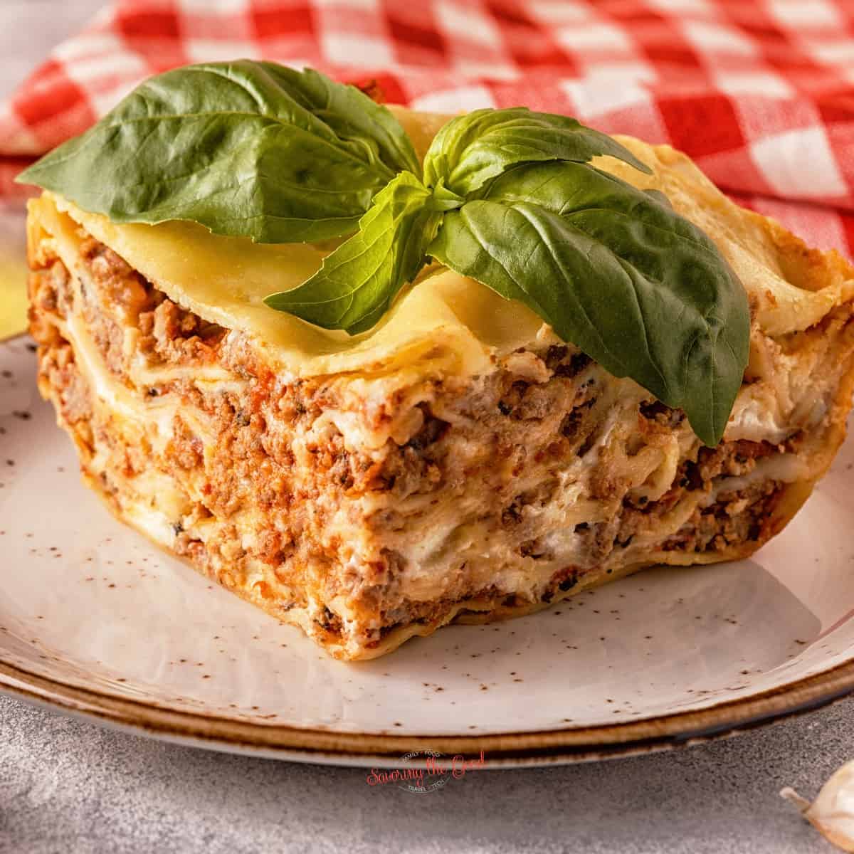 A slice of lasagna on a plate to showcase side dishes to serve with lasagna dinner.