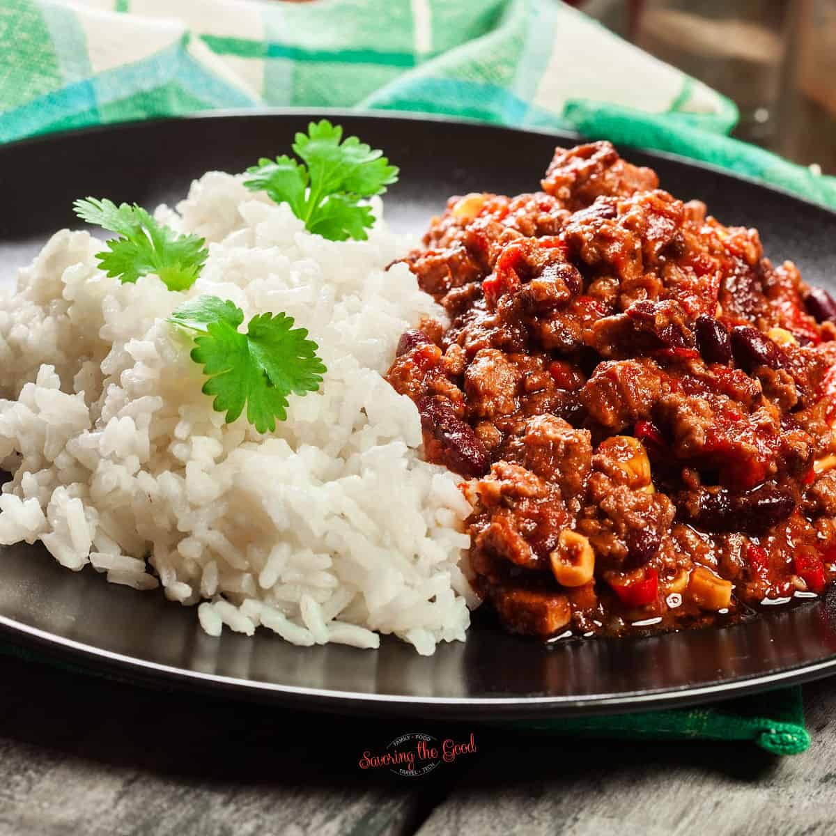 A plate with rice and chili on it.