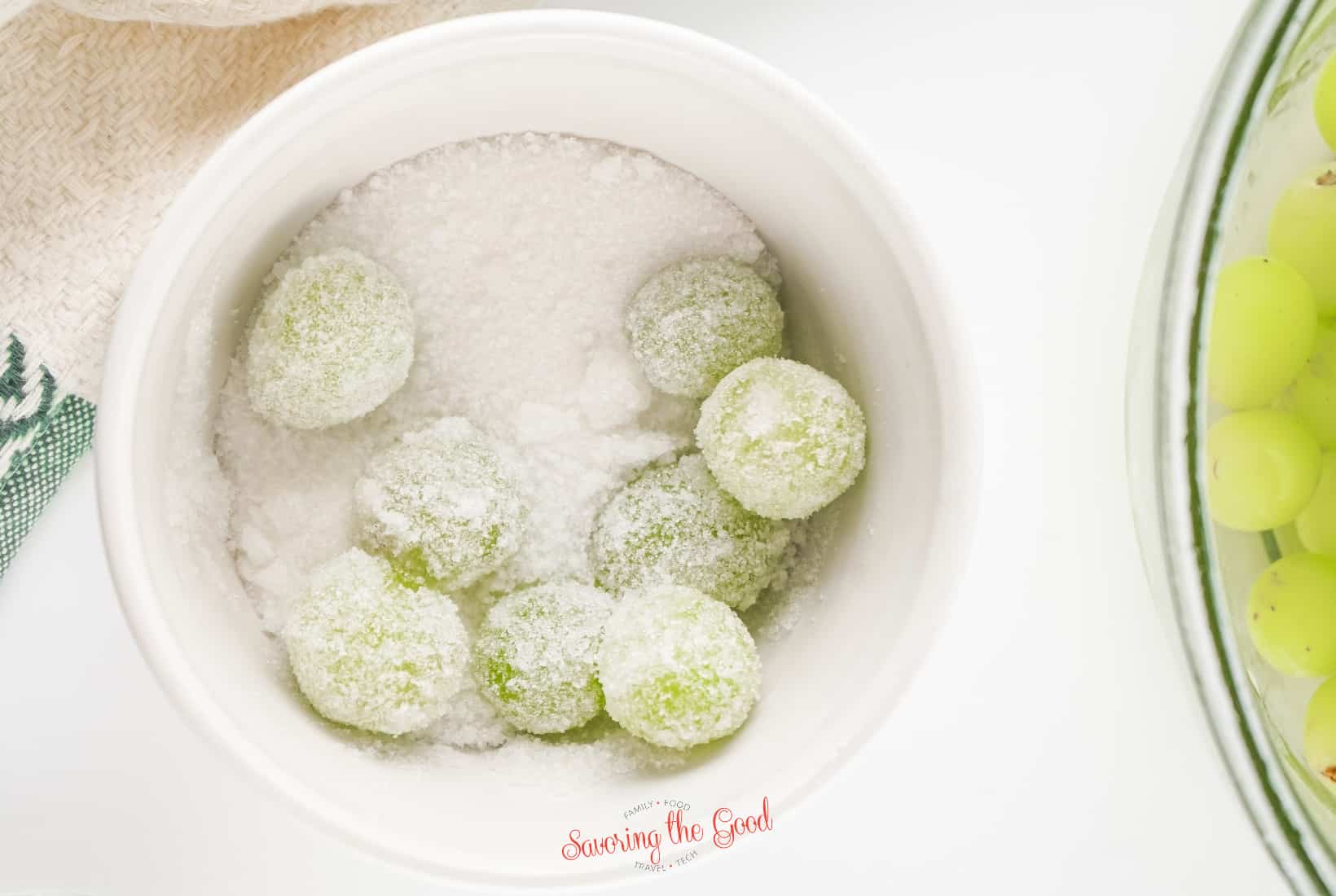 green Sugared Prosecco Grapes (Sugared Champagne Grapes) being rolled in a bowl of white sugar.