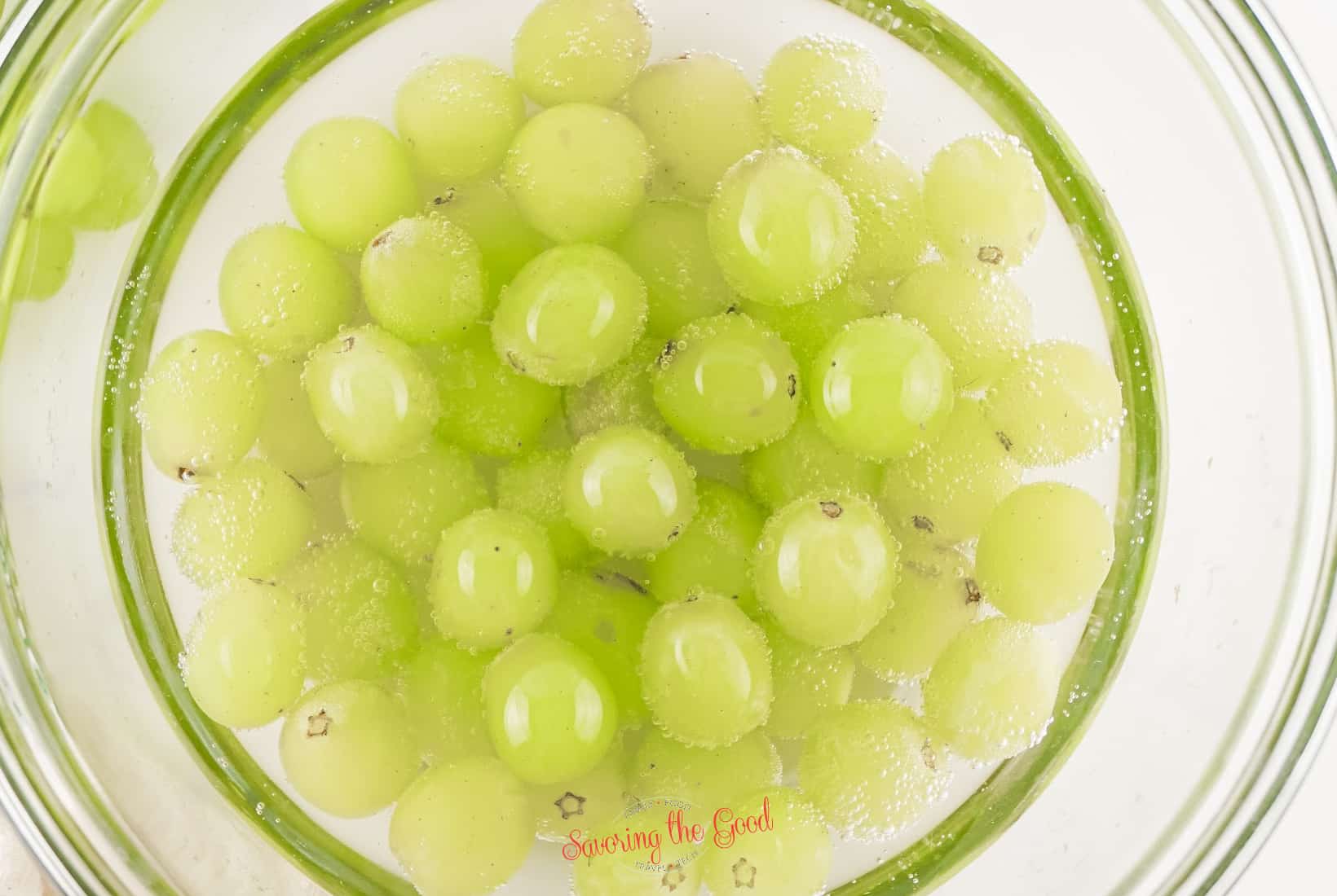 green grapes in prosecco in a clear blass bowl.